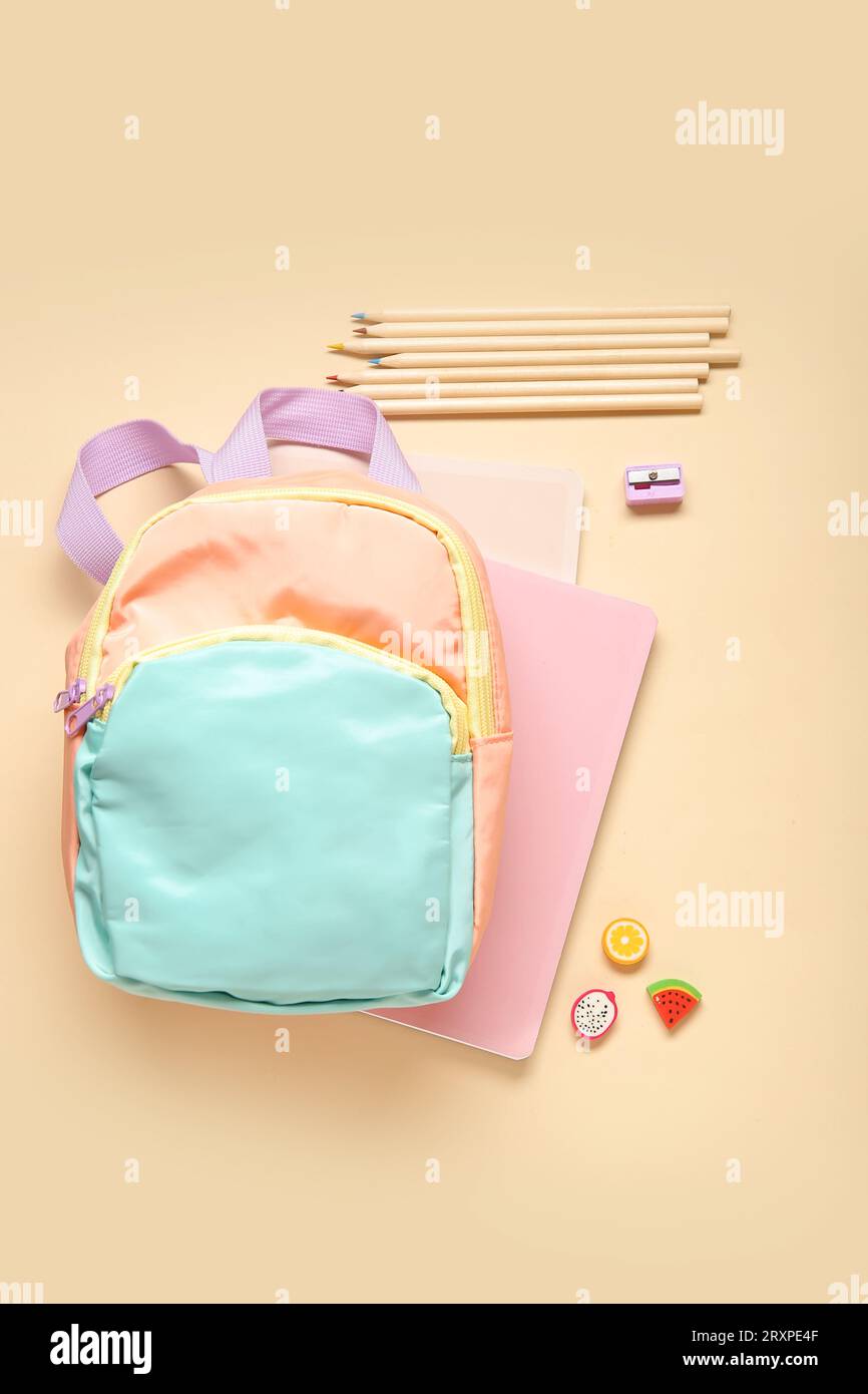 Stylish school backpack with different stationery on orange background Stock Photo