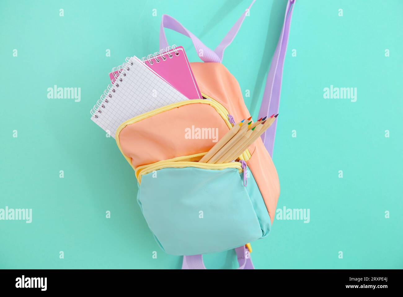 Color school backpack with stationery on turquoise background Stock Photo
