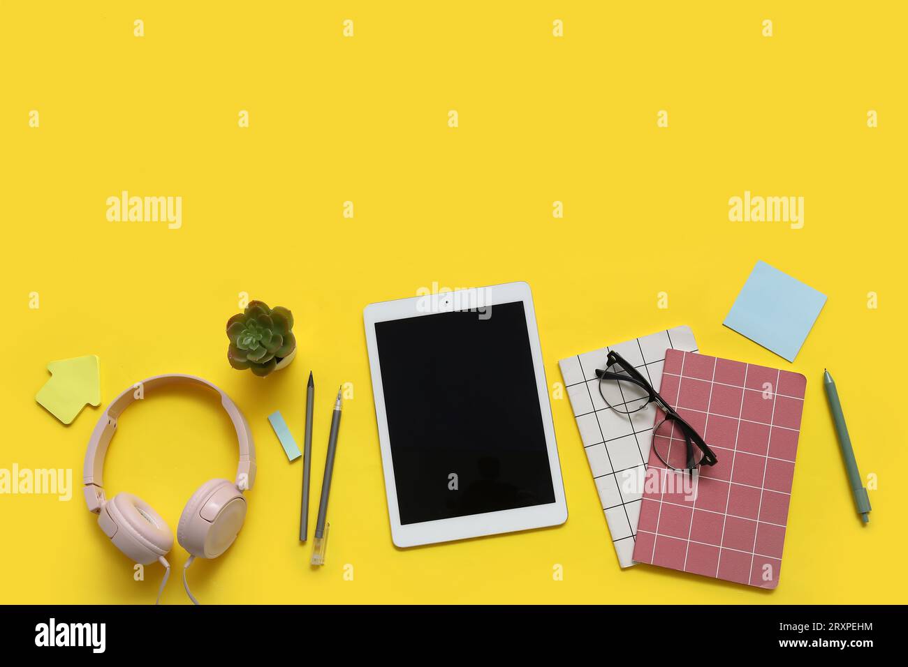 Tablet, notebooks and stationery on yellow background Stock Photo
