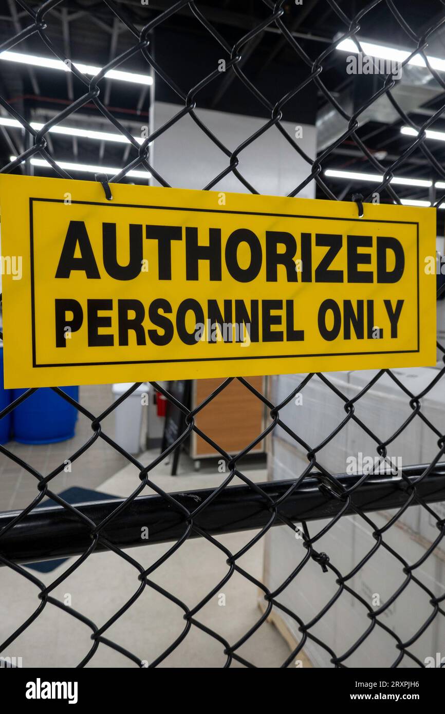 Close up of an authorized personnel only sign on a chain-link fence at a factory site, 2023, United States Stock Photo