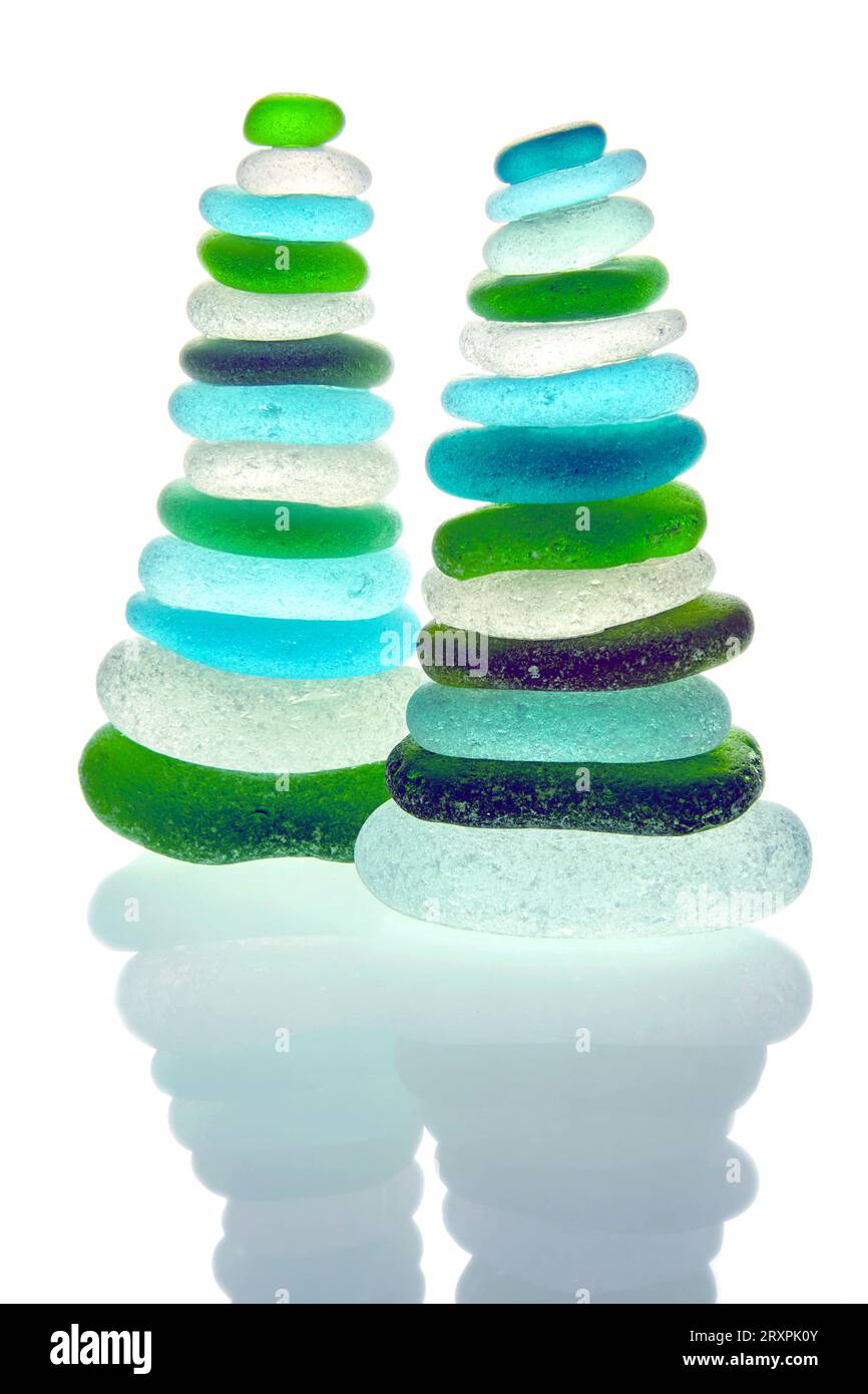 Two zen pyramids of balanced colored glass stones isolated on white