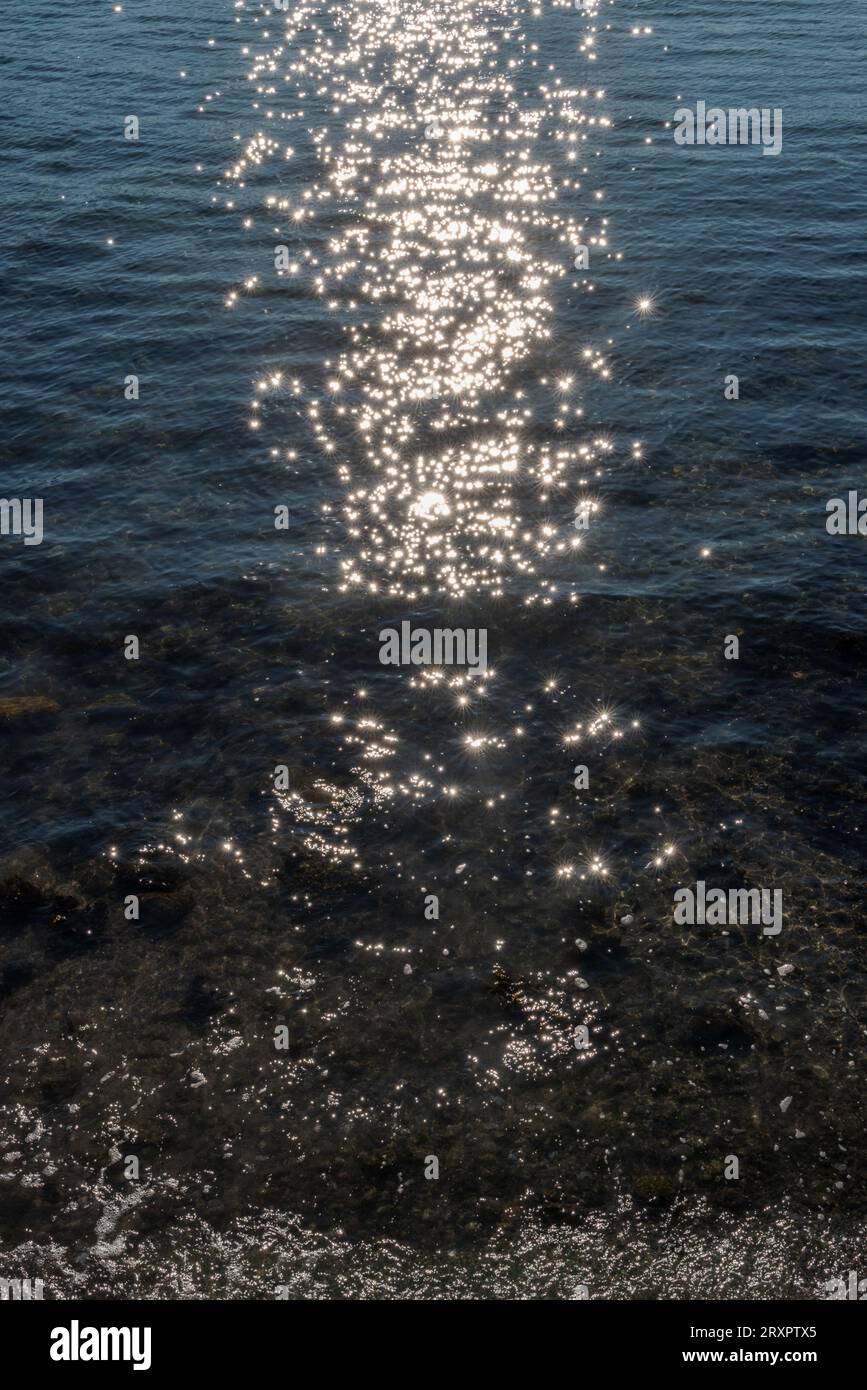 Bright sunlight sparkles on the clear blue water of the Pacific Ocean ...