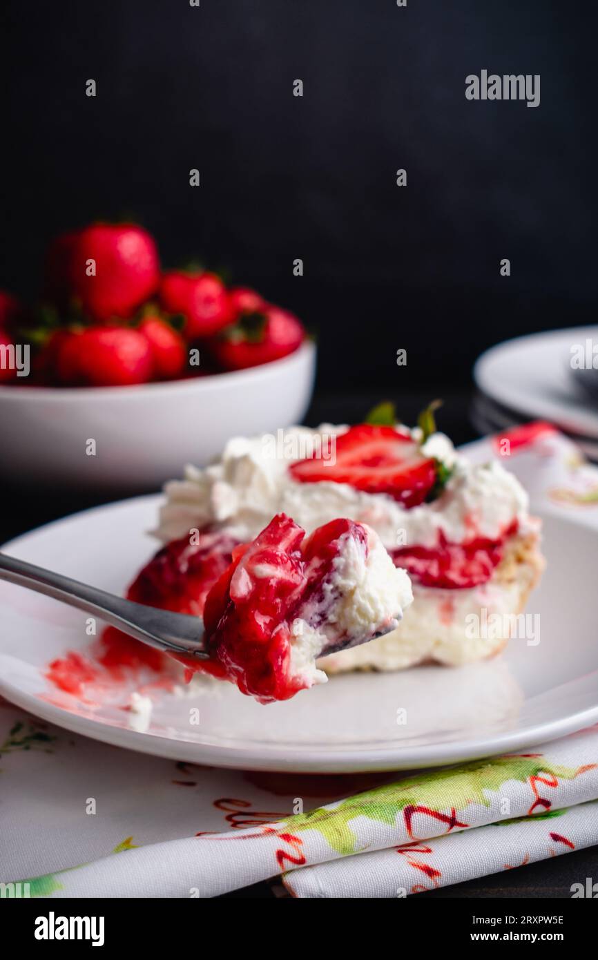 Fork Holding a Bite of Strawberry Cream Pie with Whipped Cream Eating
