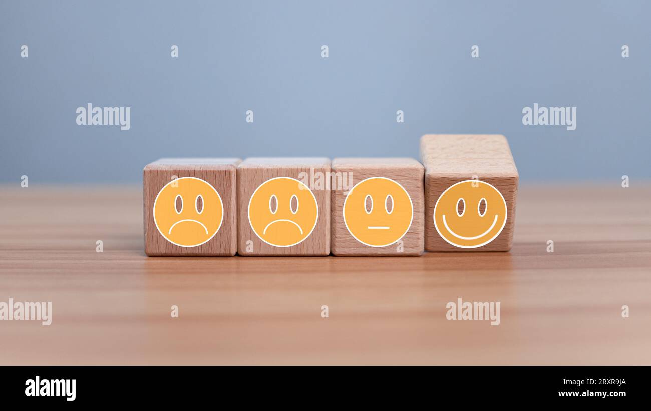 Mental health and emotional state concept, Smile face  and sad face on wooden block cube for positive mindset selection concept. Stock Photo