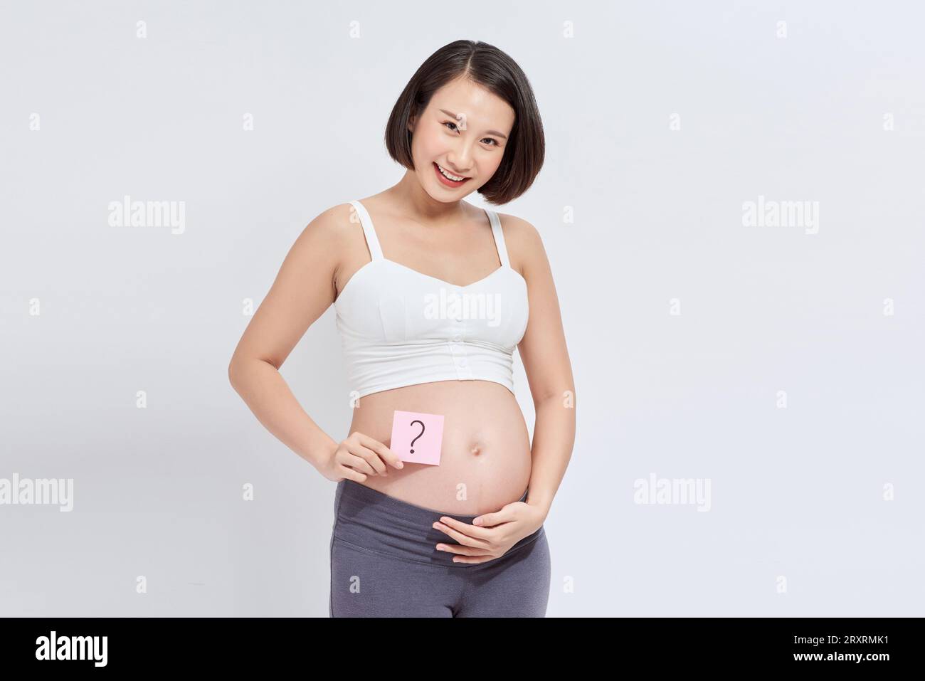 Pregnant woman with a sticky note, which is drawing a question sign, on her belly Stock Photo