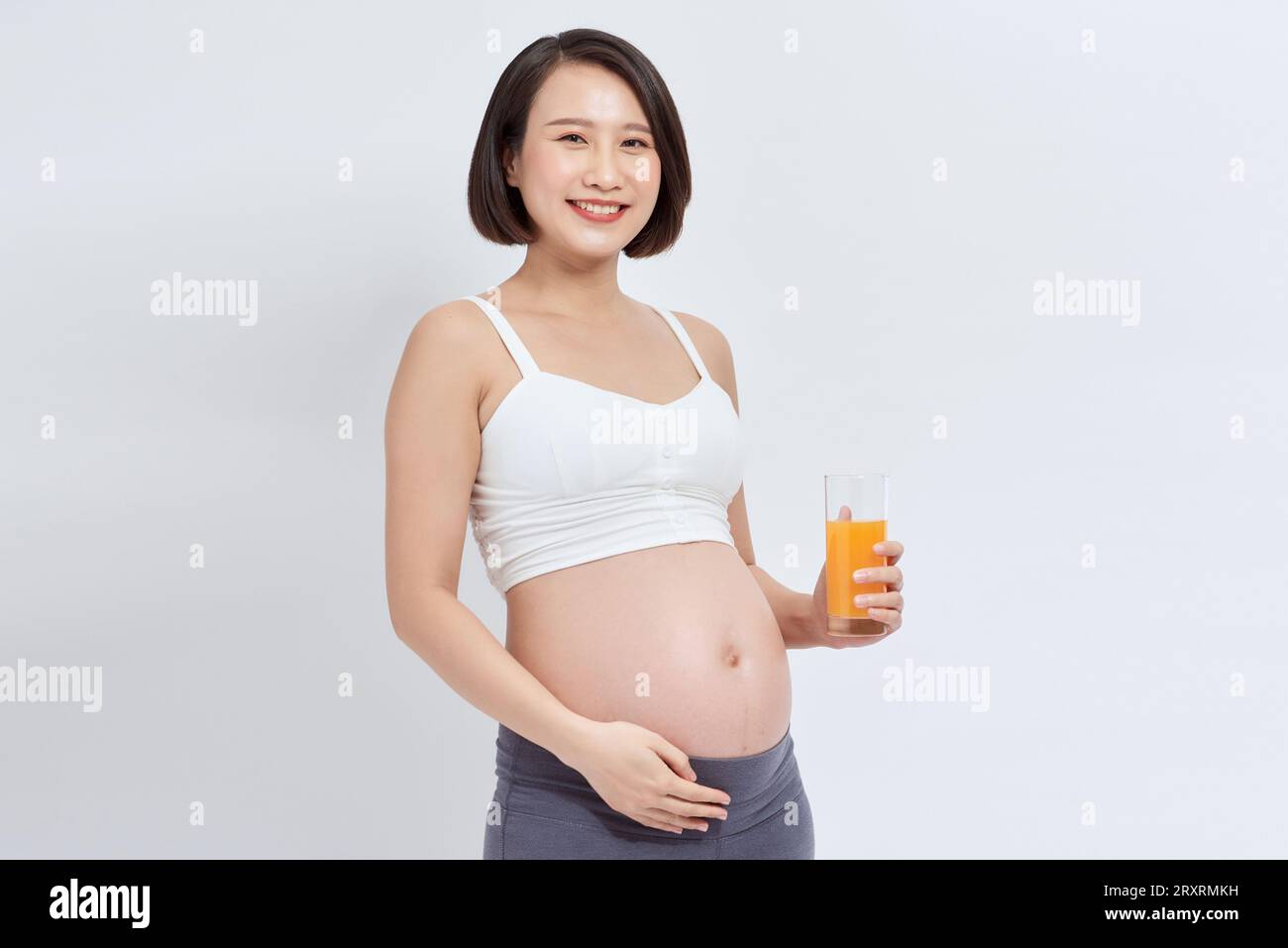 Pretty young pregnant woman with glass of orange juice. isolated on ...