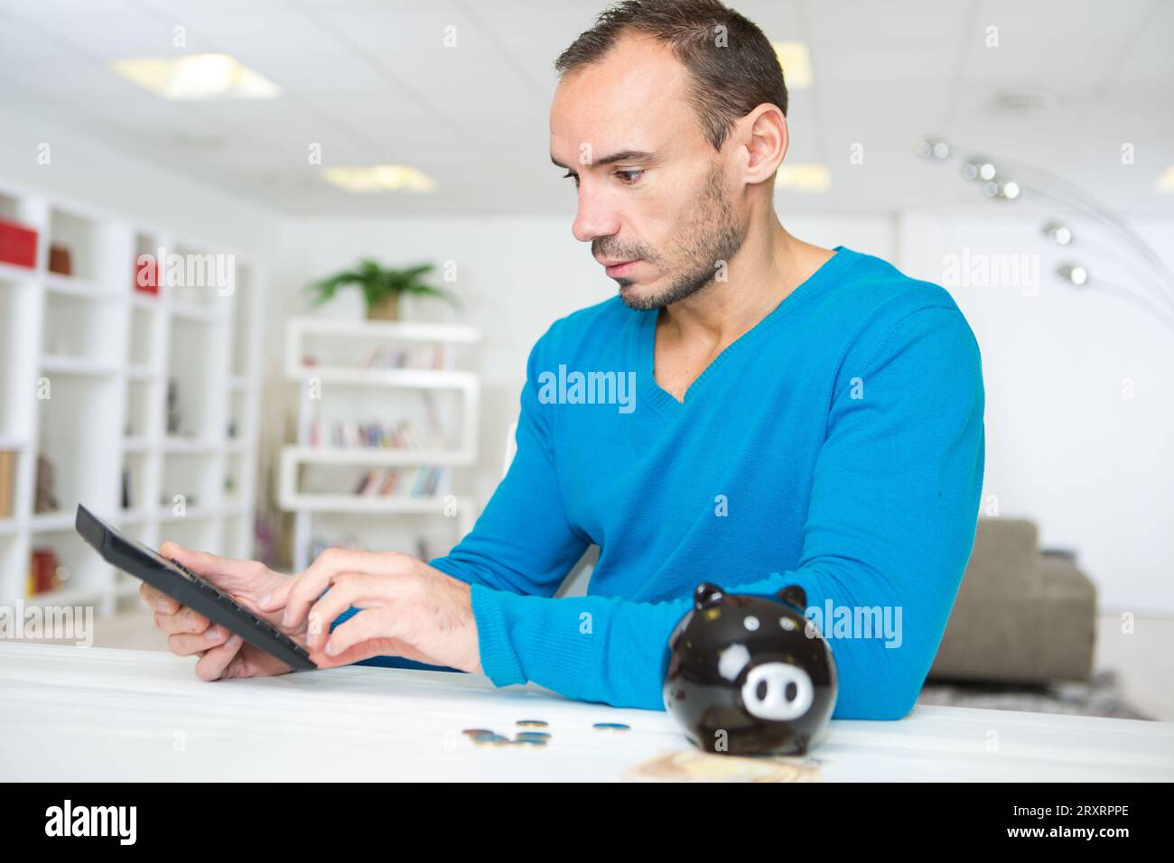 man using a piggy bank with calculator Stock Photo - Alamy