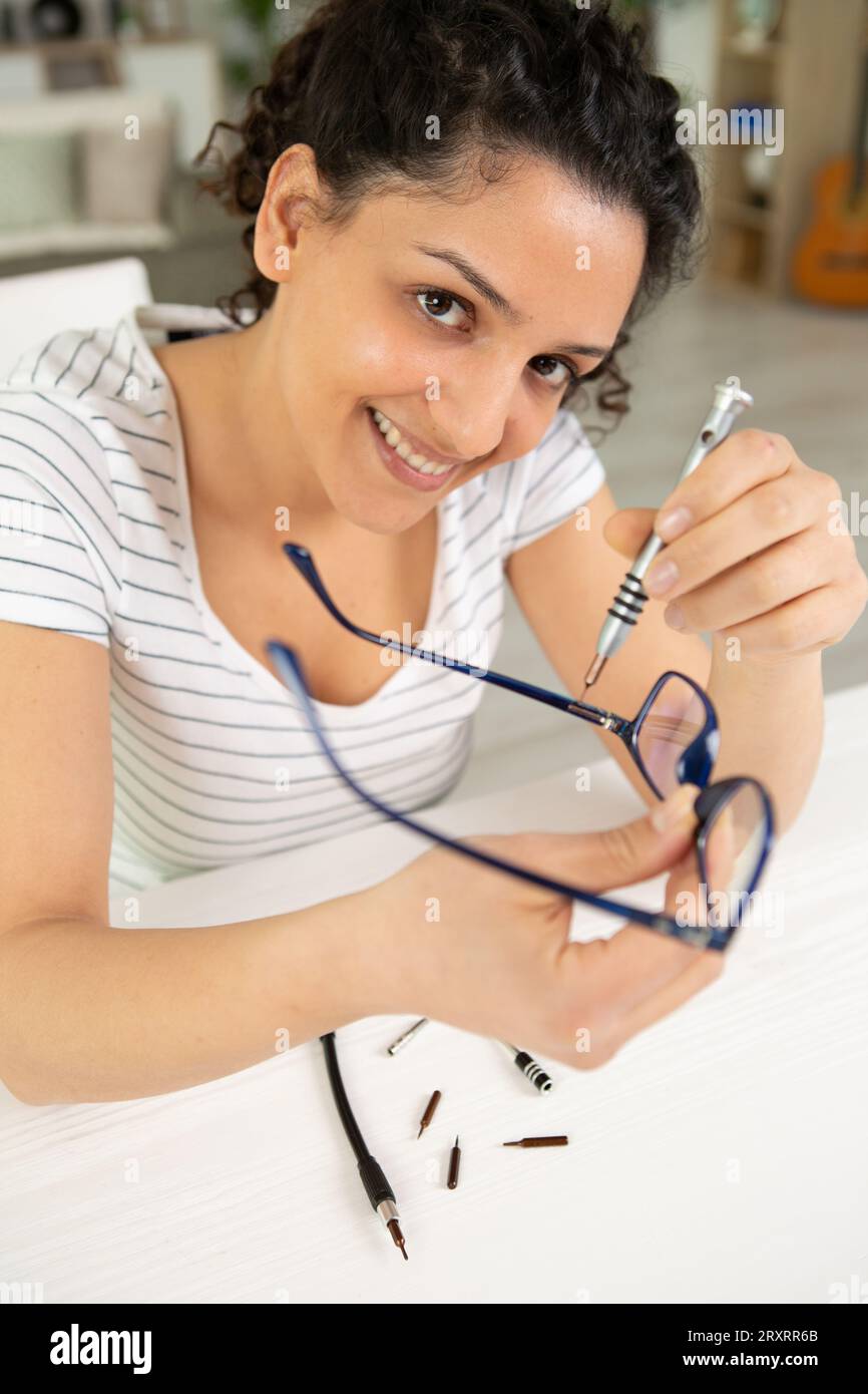 young female technician repairing glasses Stock Photo