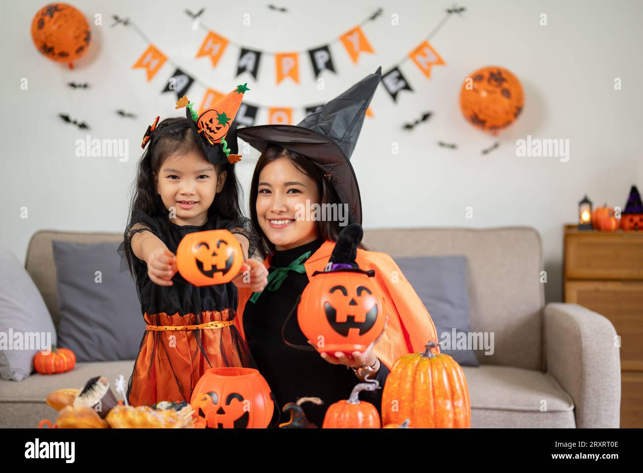 A portrait of a cheerful Asian mom and her little daughter dressed in