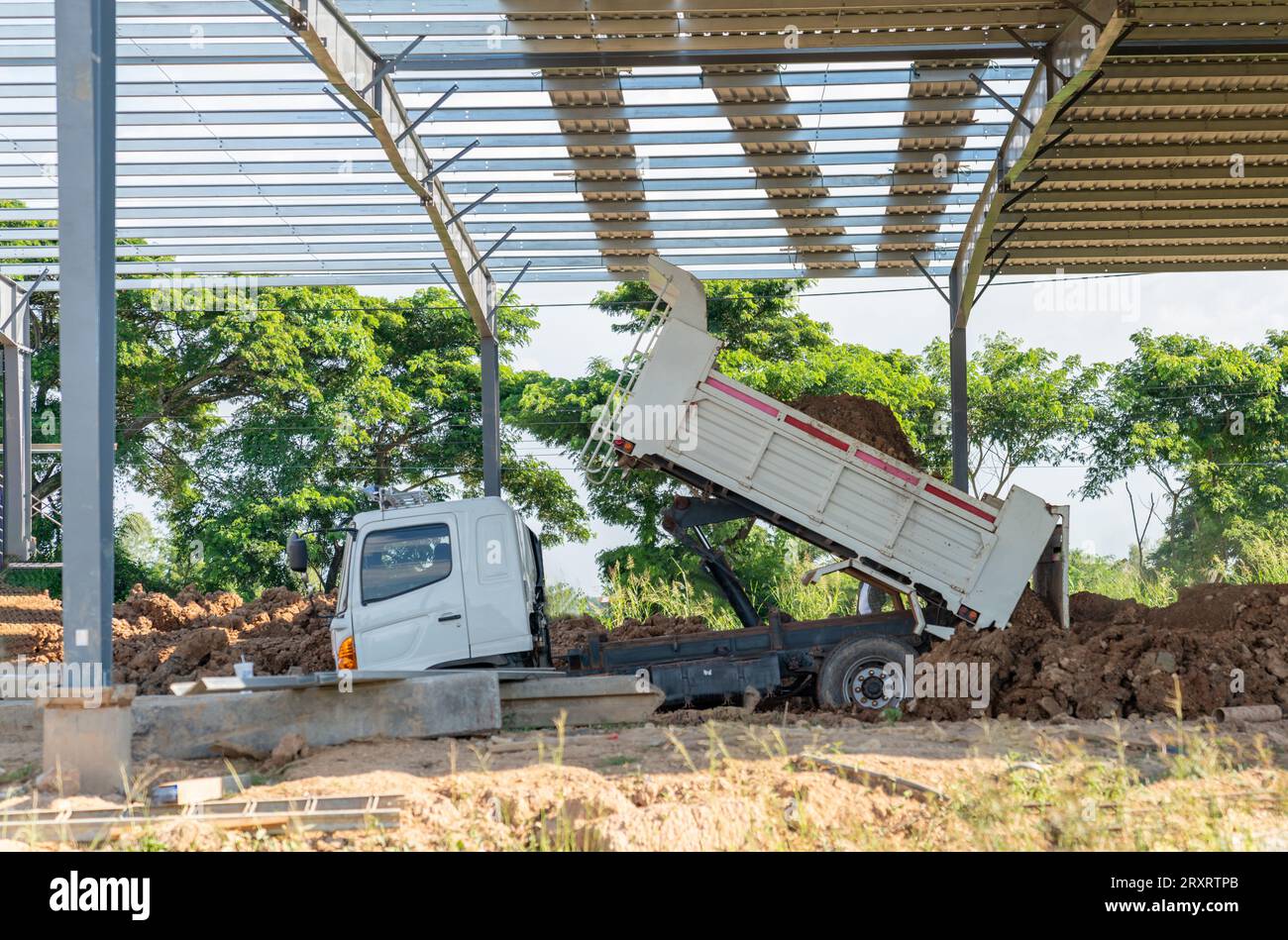 The dumper truck load out soil to leveling godown floor in construction site. Stock Photo