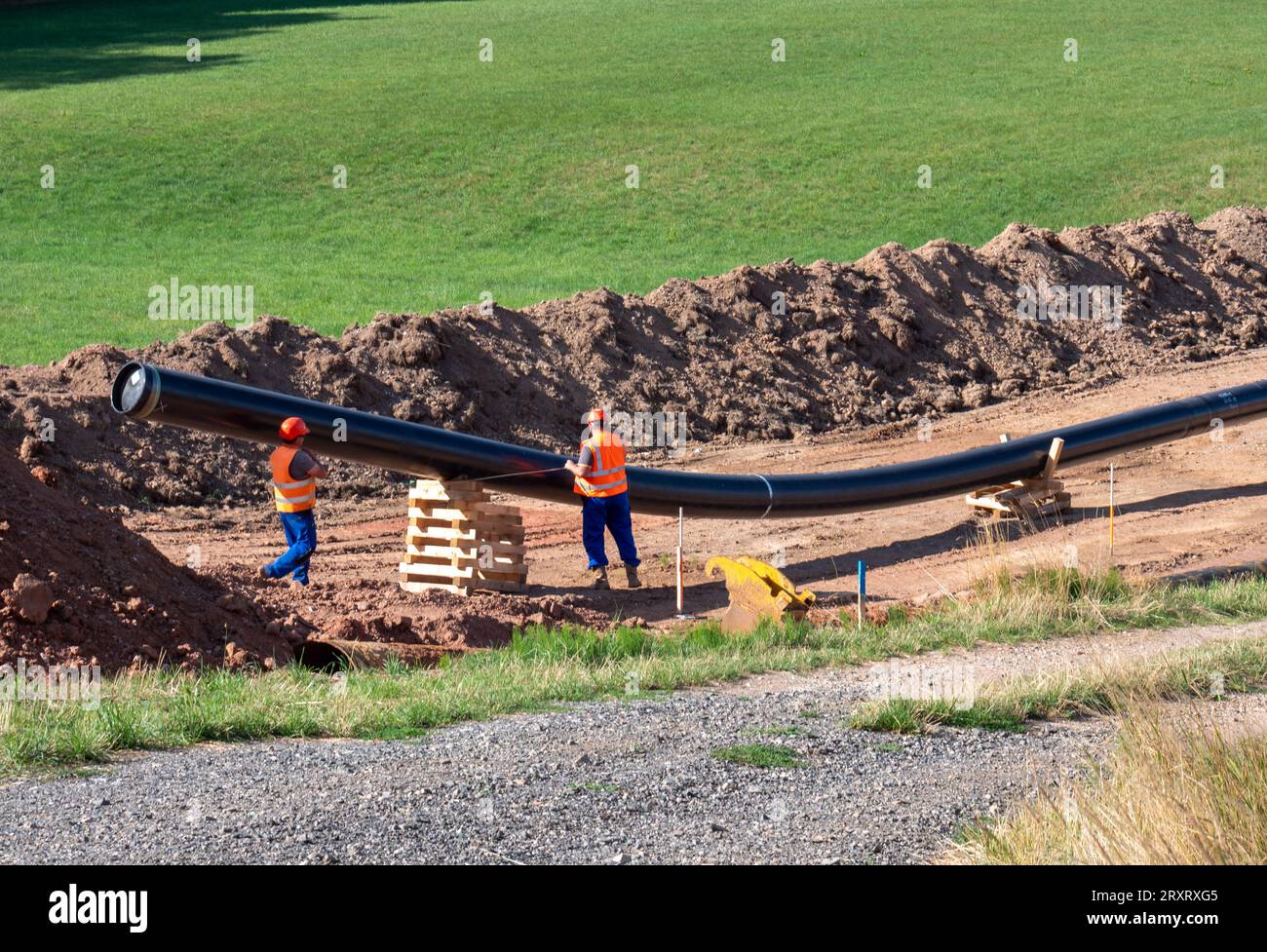 Laying a gas pipe route on the construction site with worker Stock Photo
