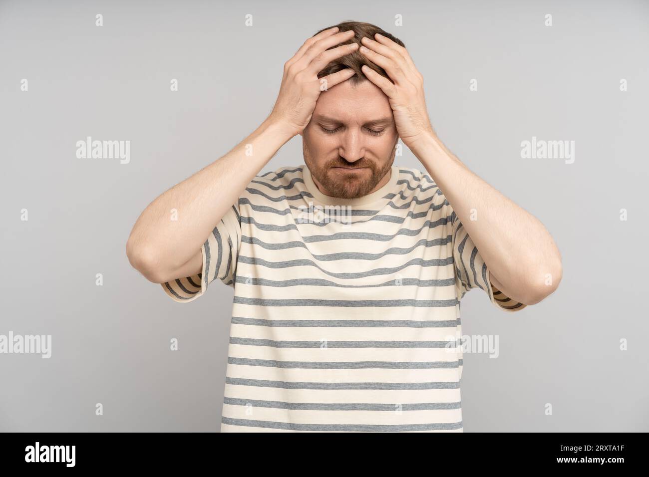 Extremely disappointed man holds head. Suffering discouragement mental breakdown stress headache Stock Photo