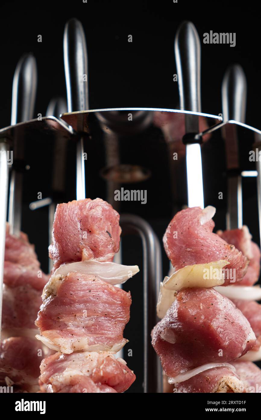 https://c8.alamy.com/comp/2RXTD1F/cooking-pork-meat-in-an-electric-kebab-maker-on-vertical-skewers-2RXTD1F.jpg