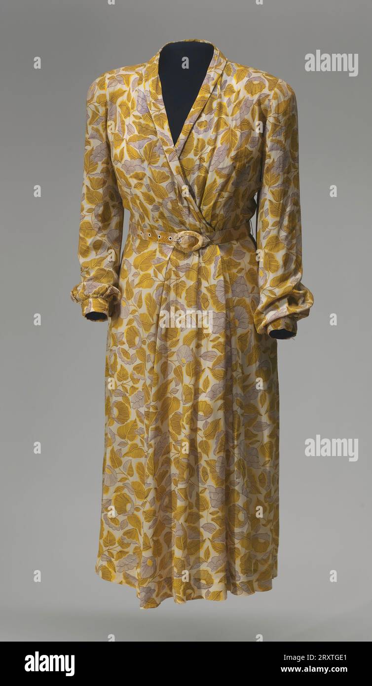 This dress is a wrap style made from a plain weave viscose fabric with a  printed design of dark brown and yellow flowers and leaves. The wrap effect  is achieved by crossing