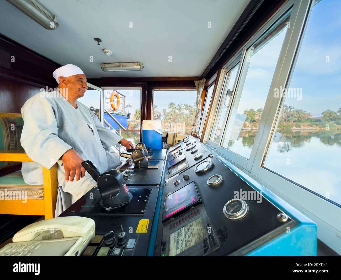 Egyptian Captain of the Oberoi Philae at the helm on the Nile River, Dendera, Egypt, North Africa, Africa Stock Photo