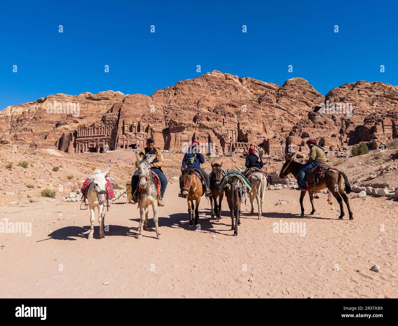Donkeys and riders, Petra Archaeological Park, UNESCO World Heritage Site, one of the New Seven Wonders of the World, Petra, Jordan, Middle East Stock Photo