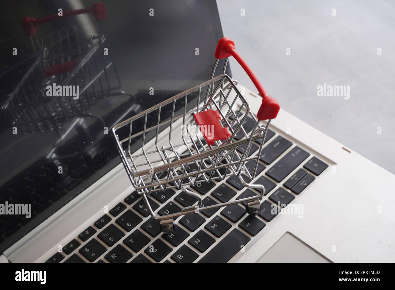 Closeup image of shopping trolley on top of laptop keyboard. Business and technology concept Stock Photo