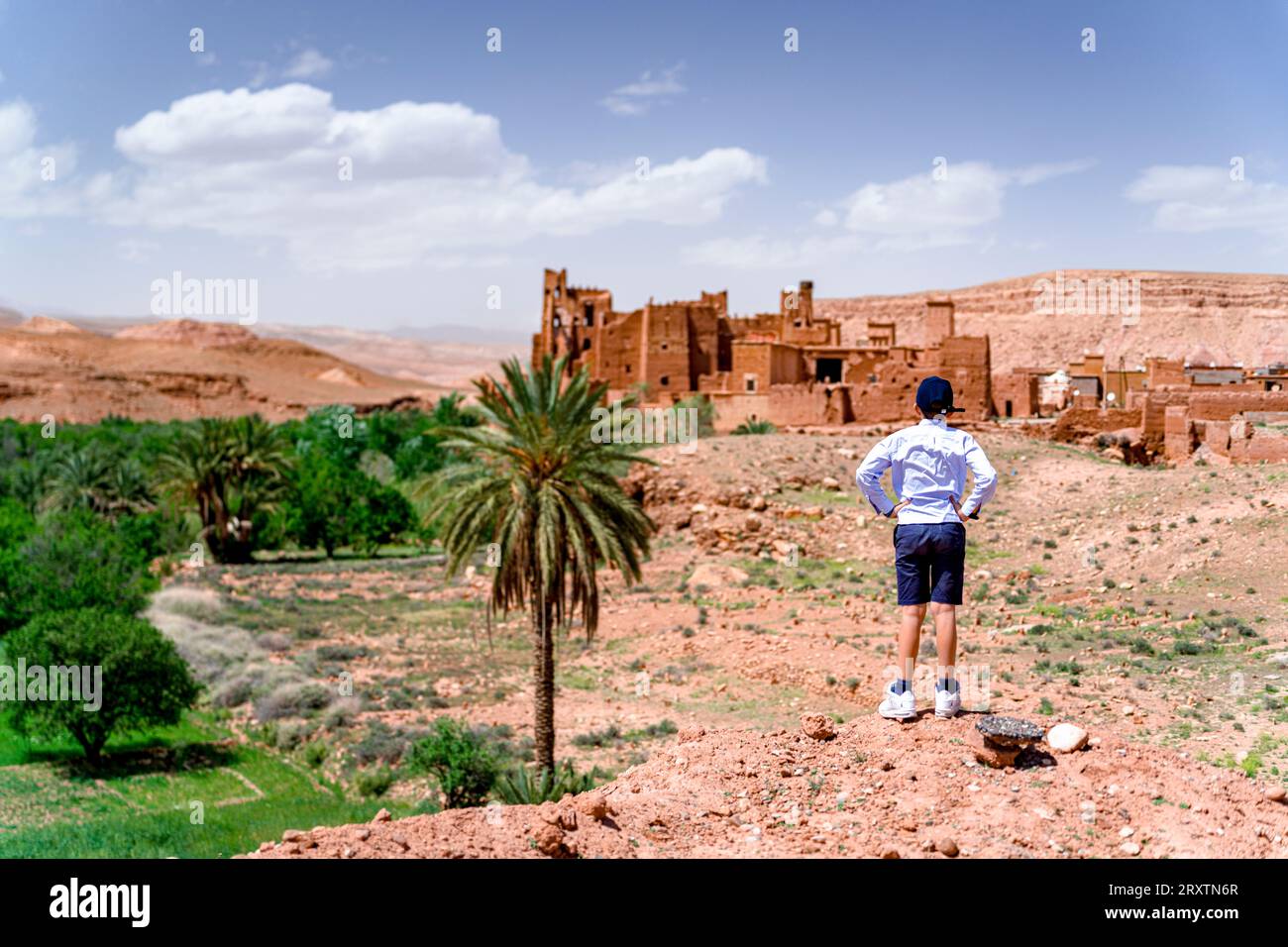 Rear view of boy admiring an old kasbah, Ounila Valley, Atlas mountains, Ouarzazate province, Morocco, North Africa, Africa Stock Photo