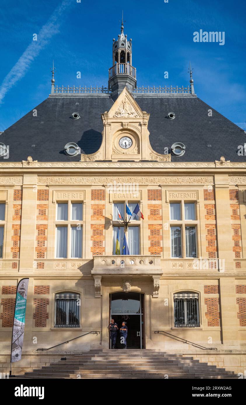 Two police officers stand in front of the Mairie de Montrouge, or Montrouge Town Hall, in Montrouge,  a suburb just south of Paris, France. Stock Photo