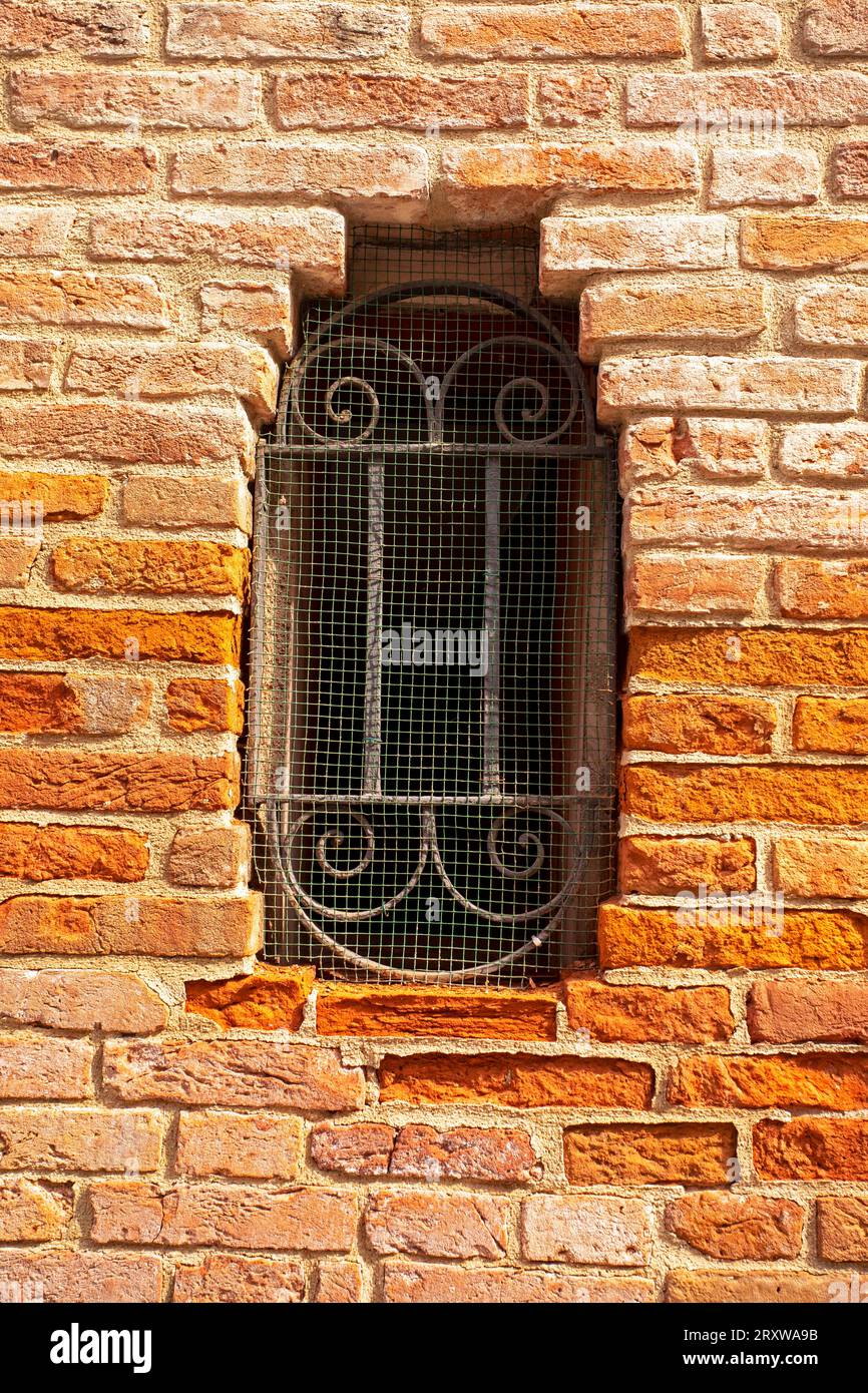 old semicircular window with bars in the wall Stock Photo - Alamy