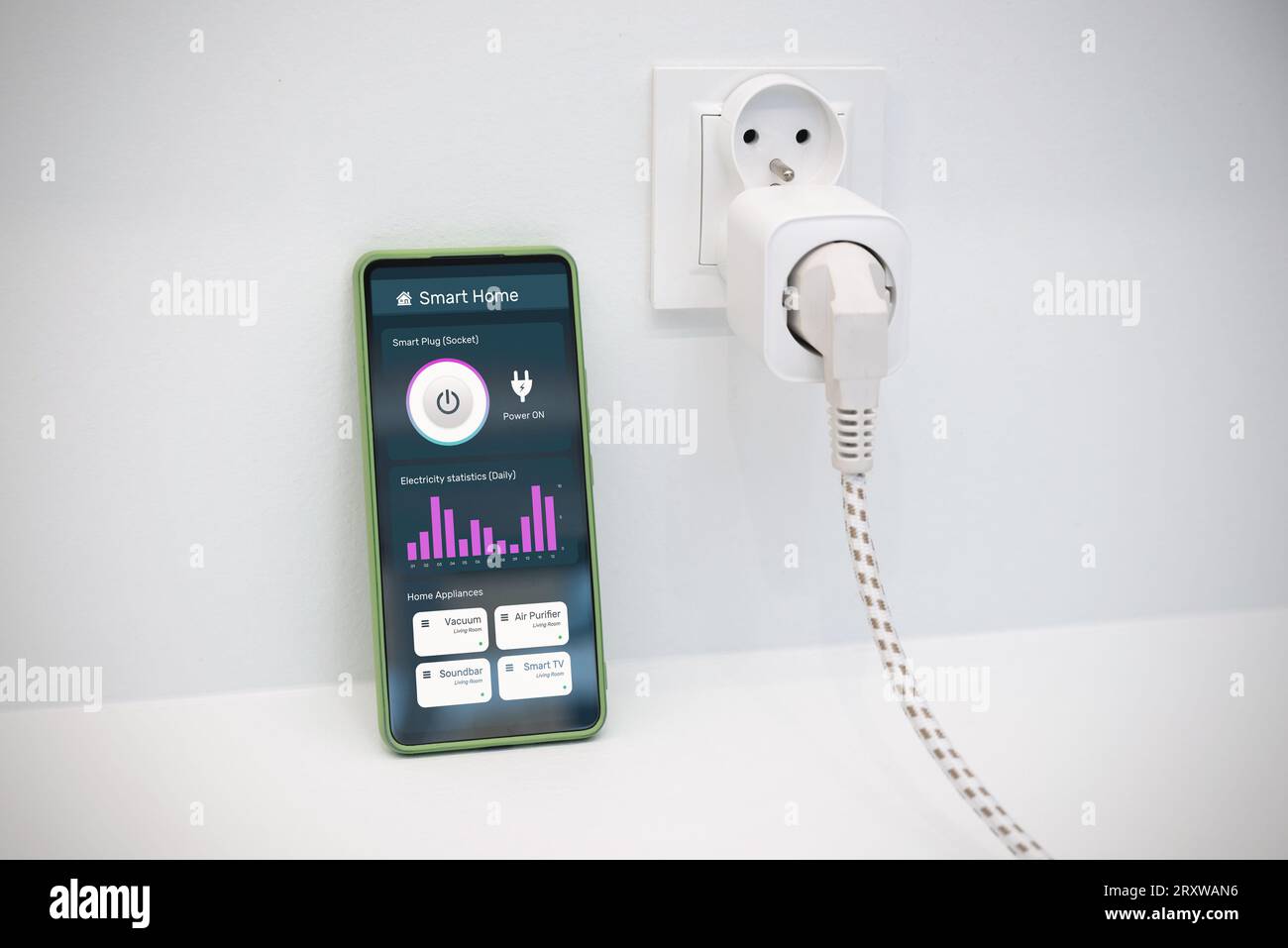 Using Wi-fi smart socket on the wall in a smart home, controlling electricity consumption Stock Photo