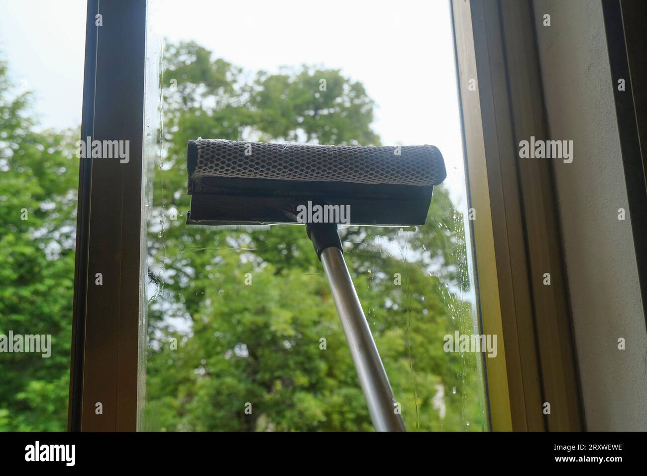 cleaning the window with a window cleaning mop closeup. Cleaning services Stock Photo