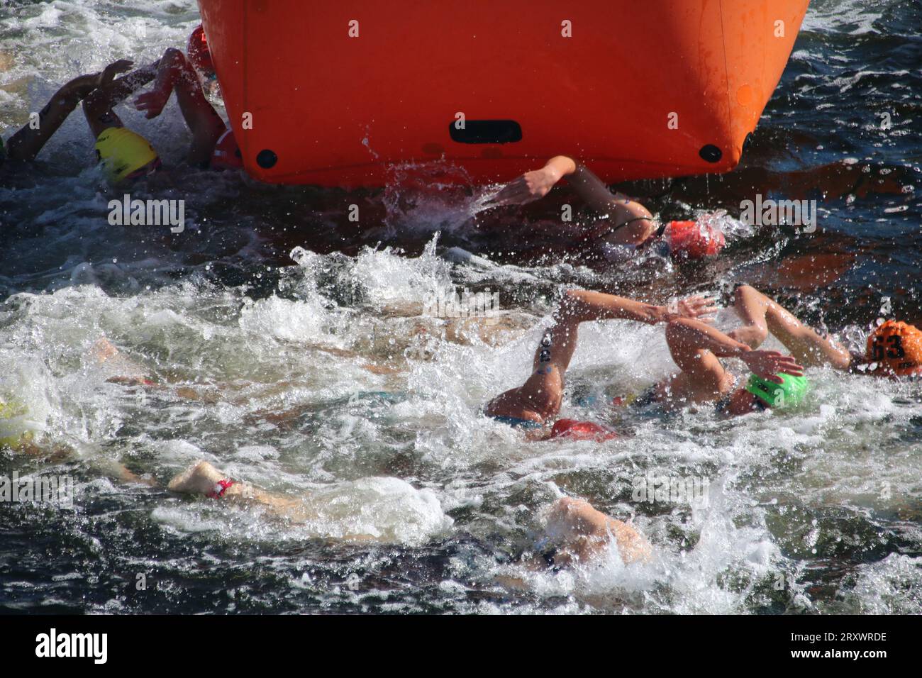 triathletes in the washing machine turn around a buoy on their swim leg ...