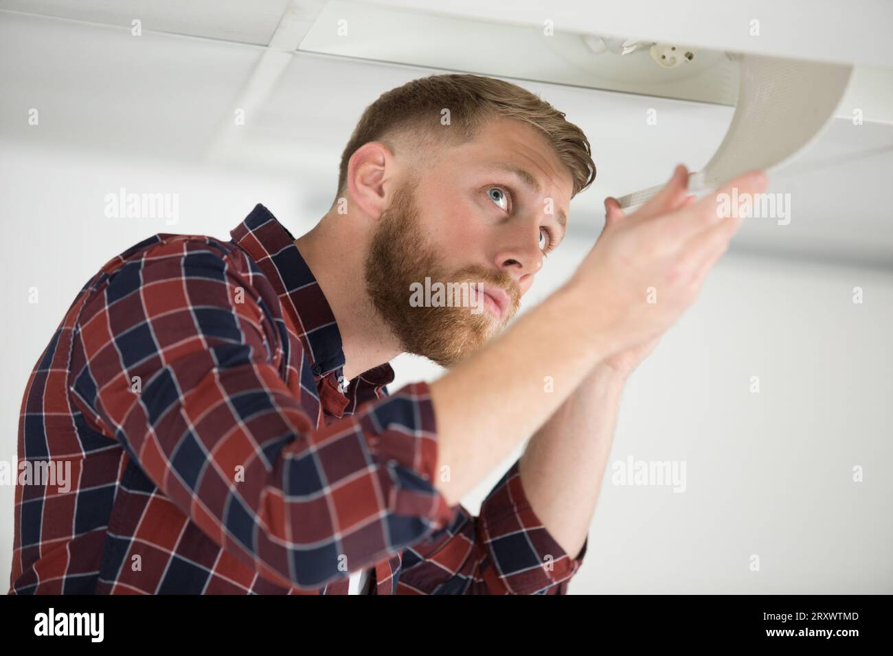 man replacing the light bulb on the ceiling Stock Photo - Alamy
