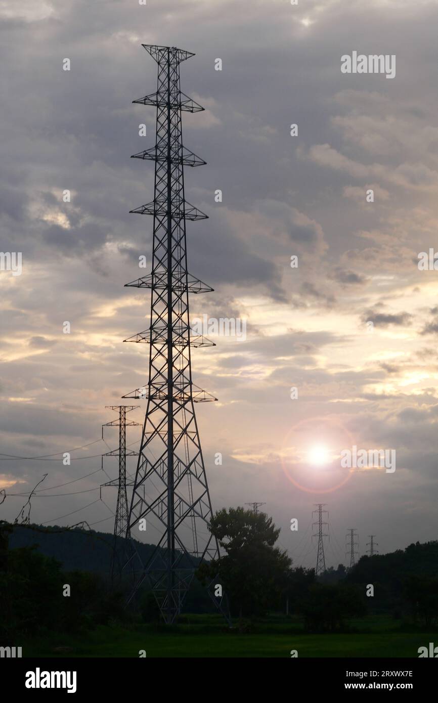 High voltage tower with power lines with Sunlight ray in the evening ...