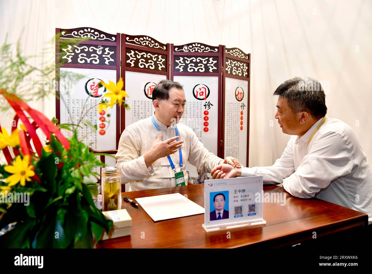(230927) -- QUFU, Sept. 27, 2023 (Xinhua) -- A doctor (L) conducts a pulse diagnosis for a participant of the Ninth Nishan Forum on World Civilizations in Qufu, east China's Shandong Province, Sept. 27, 2023.  The forum on Confucius culture kicked off Wednesday in the city of Qufu, the birthplace of the prominent Chinese philosopher.   The Nishan Forum on World Civilizations, the ninth since its inception in 2010, has attracted 330 foreign guests, including politicians, representatives from international organizations, diplomats to China, experts and scholars. (Xinhua/Guo Xulei) Stock Photo