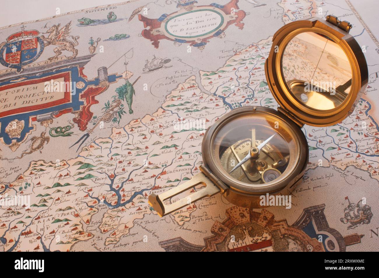 An old brass compass lying on an ancient map of Cornwall - John Gollop Stock Photo