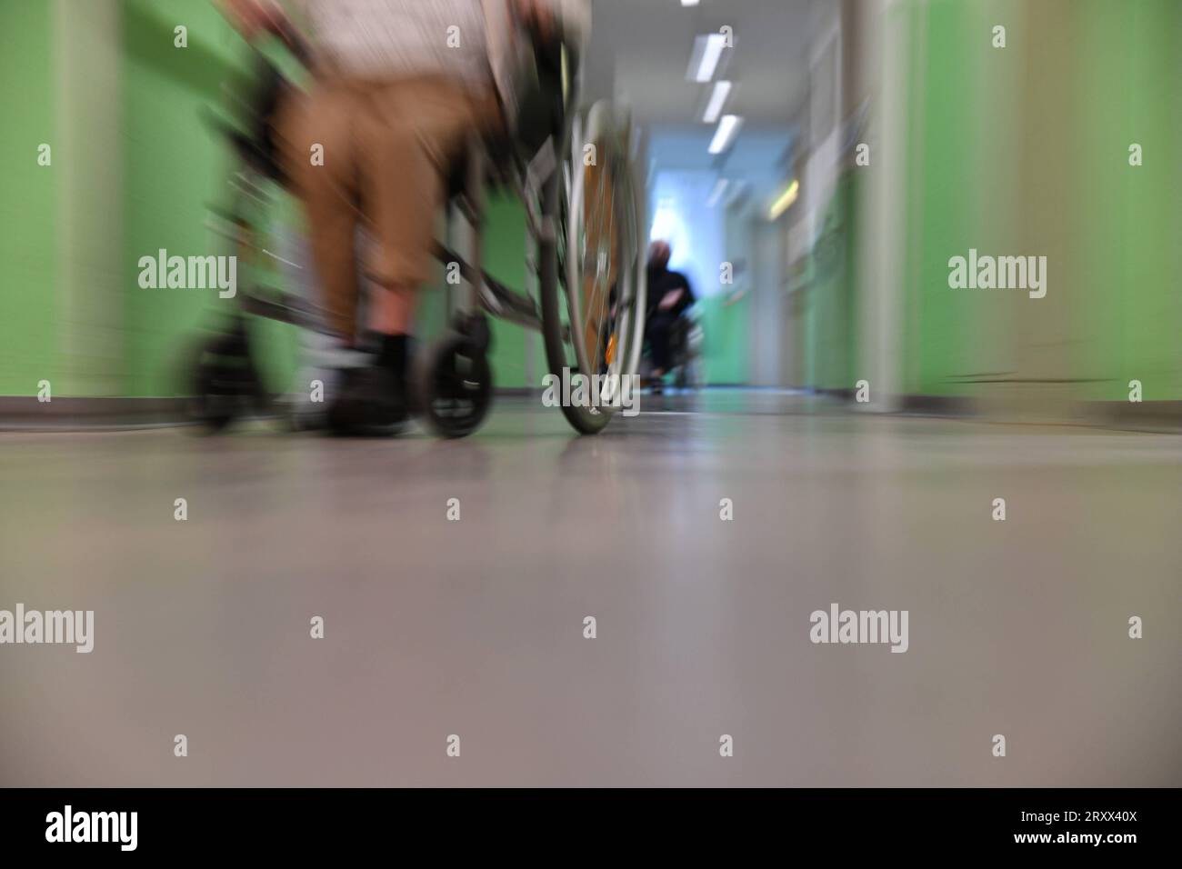 Ein Mann sitzt in einer Pflegeeinrichtung auf einem Flur im Rollstuhl und wartet. Symbolfoto: Pflege, Altenheim, Senioren, Alte, Pflege, Pflegeeinrichtung, Heim, Krankenhaus, Älterwerden *** A man sits in a wheelchair in a hallway in a nursing facility waiting symbol photo care, nursing home, seniors, old, care, nursing facility, home, hospital, aging bub Stock Photo