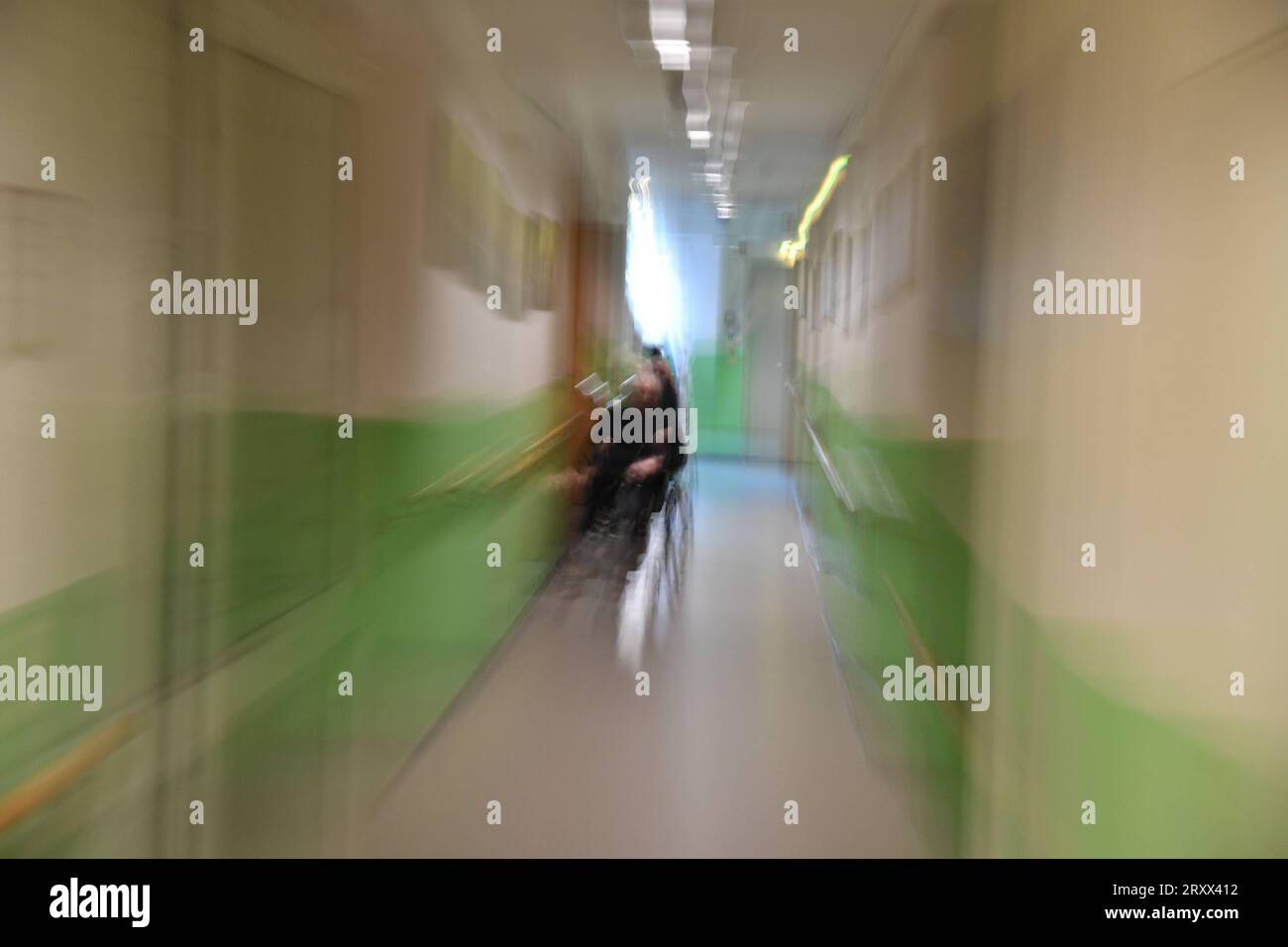 Ein Mann sitzt in einer Pflegeeinrichtung auf einem Flur im Rollstuhl und wartet. Symbolfoto: Pflege, Altenheim, Senioren, Alte, Pflege, Pflegeeinrichtung, Heim, Krankenhaus, Älterwerden *** A man sits in a wheelchair in a hallway in a nursing facility waiting symbol photo care, nursing home, seniors, old, care, nursing facility, home, hospital, aging bub Stock Photo