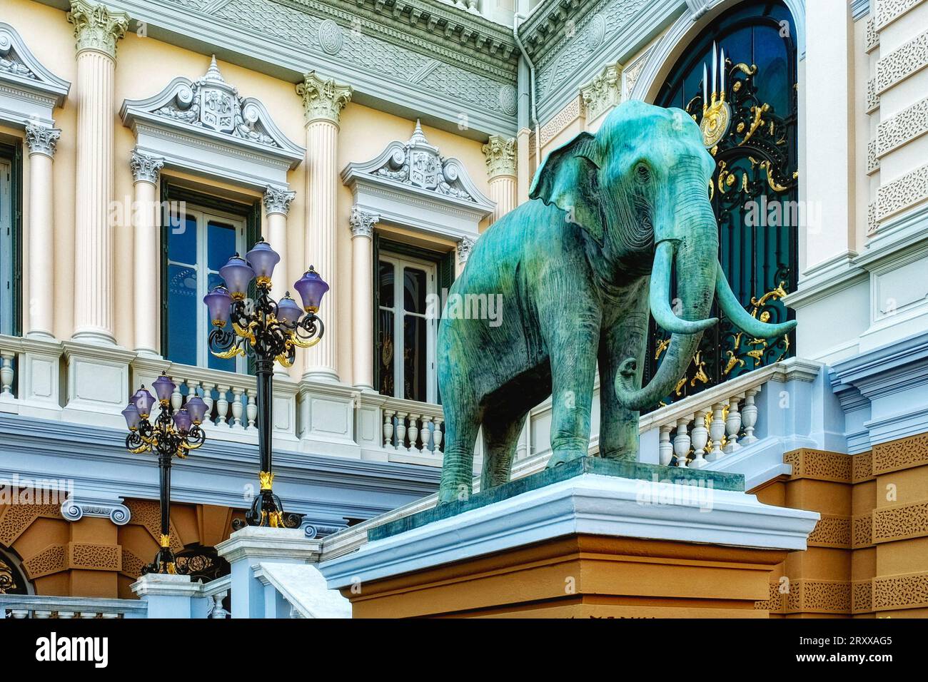 Dominating the scene is a grand elephant sculpture positioned atop a finely detailed pedestal, set before an exquisitely adorned architectural masterp Stock Photo