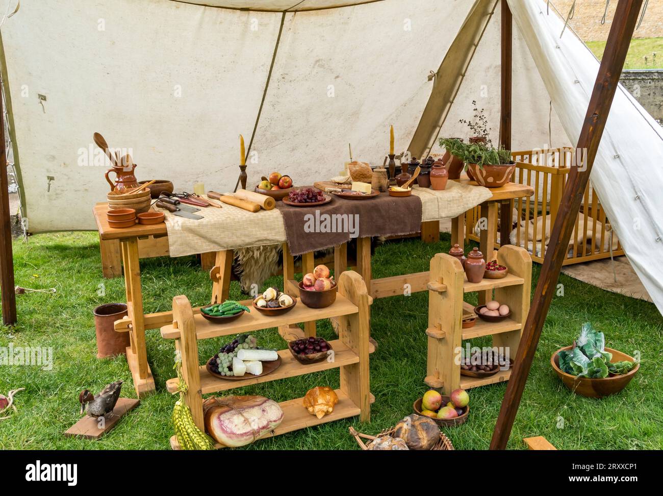 Selection of food items laid out on shelves and table in medieval pots with old kitchen tools under canvas, Jousting event, Lincoln castle, Lincoln Ci Stock Photo