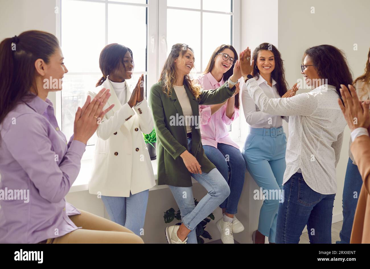 Happy women colleagues giving high five at meeting celebrating success ...