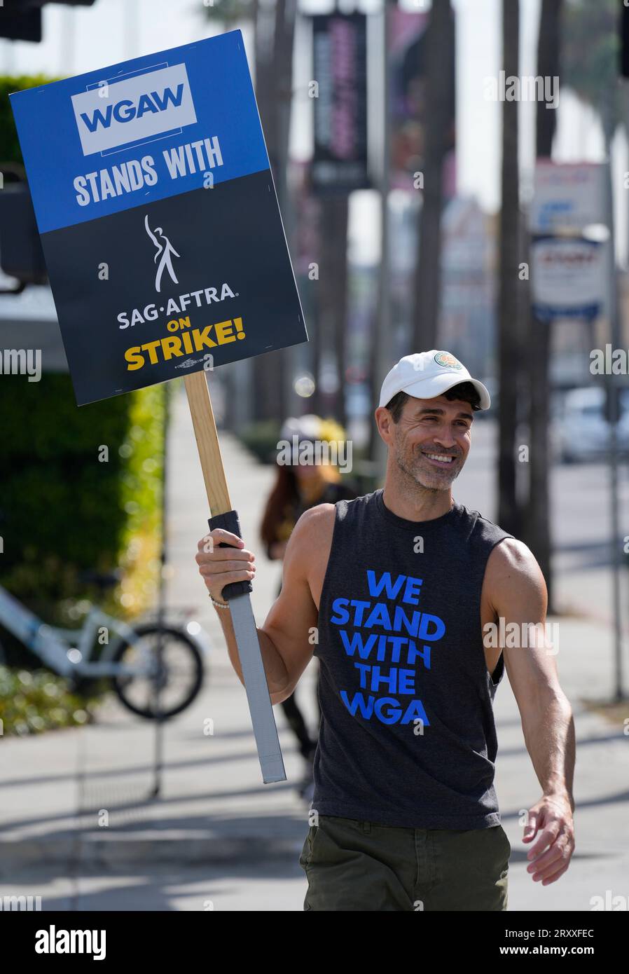 WGA member Grant Sloss carries a sign on the picket line outside 
