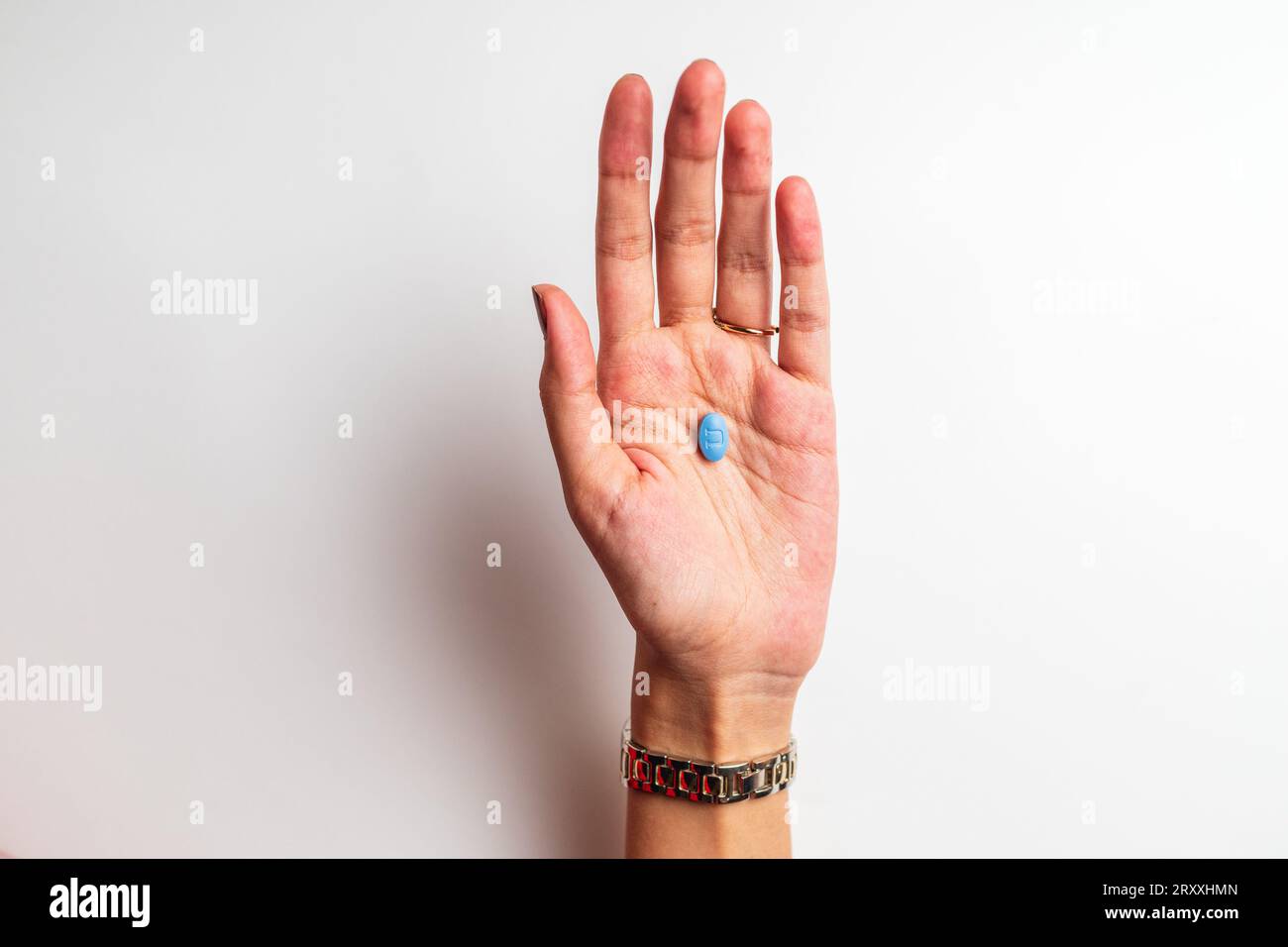 A Woman's hand holding a pill, isolated on the white background Stock Photo
