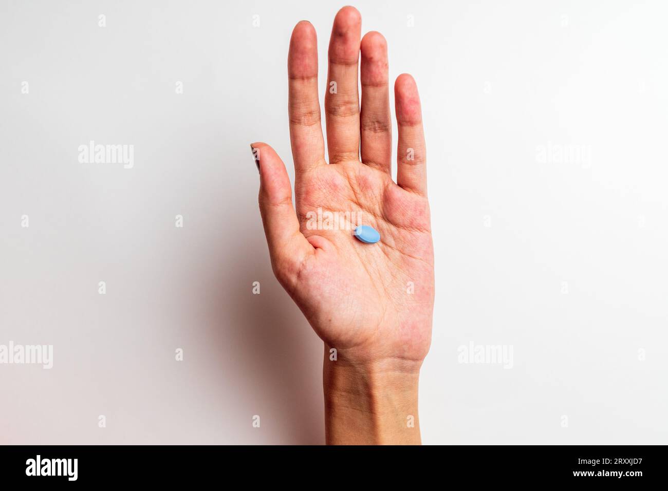 A Woman's hand holding a pill, isolated on the white background Stock Photo