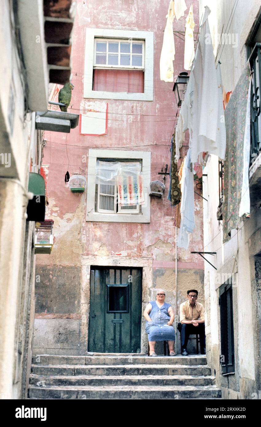 LISBON, PORTUGAL- AUGUST 09, 2017: Old couple sitting in front of their house in the Alfama area Stock Photo