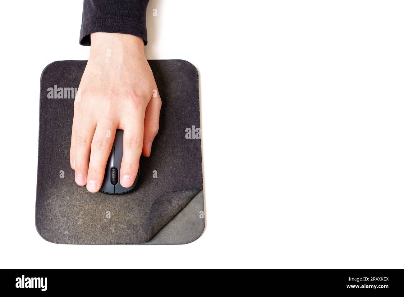Close-up top view of a male hand using a computer mouse placed on an old and spoiled mouse pad isolated on white. Stock Photo