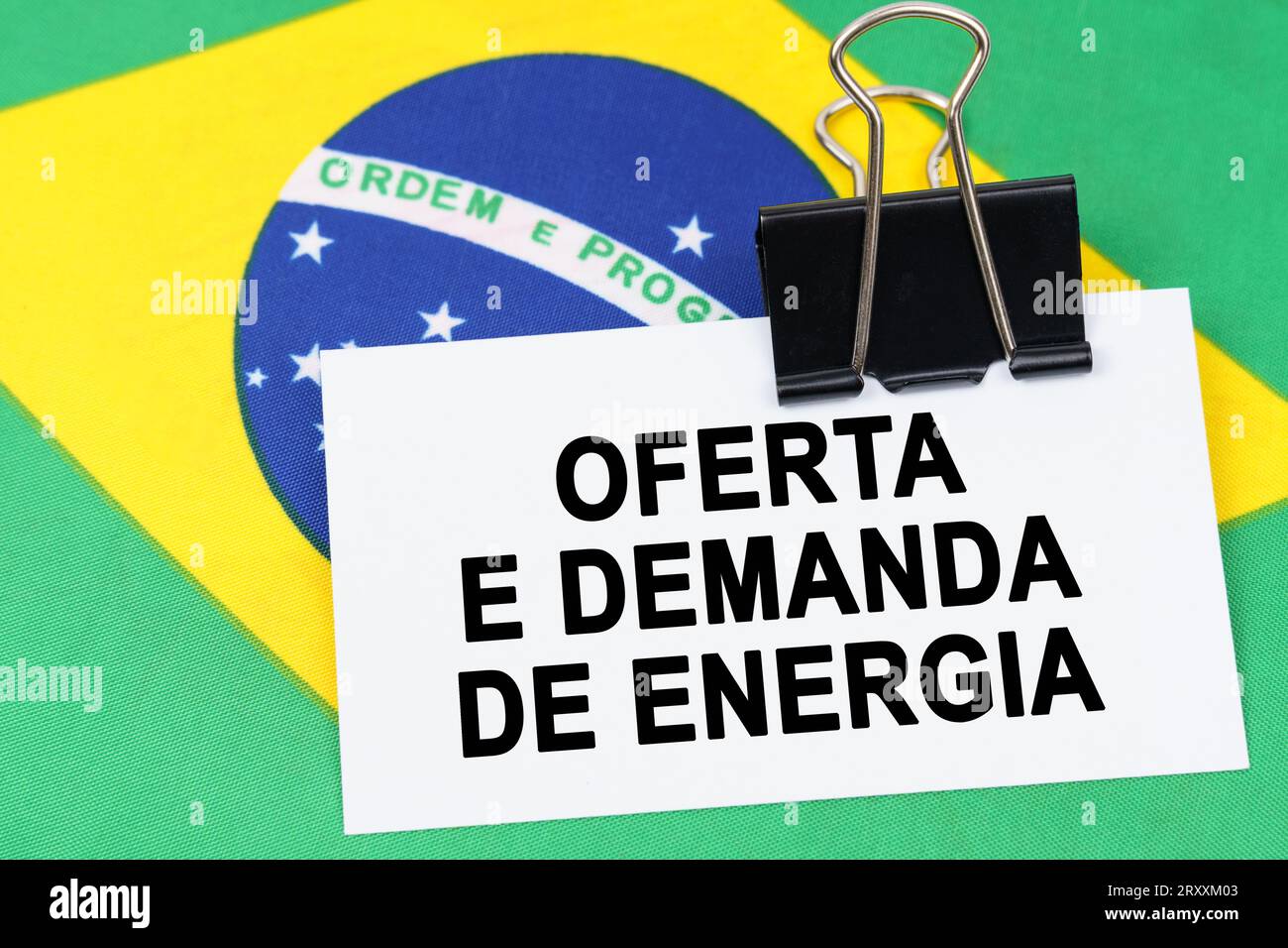 Economy and finance concept. On the flag of Brazil lies a business card with the inscription - supply and demand for energy. Text in Portuguese. Stock Photo