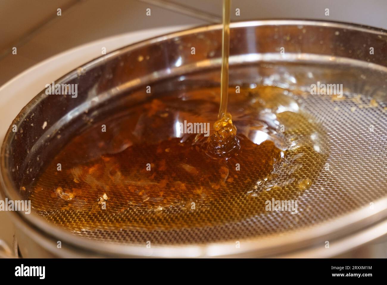 Honey production. Honey flows out of the honey extractor onto the