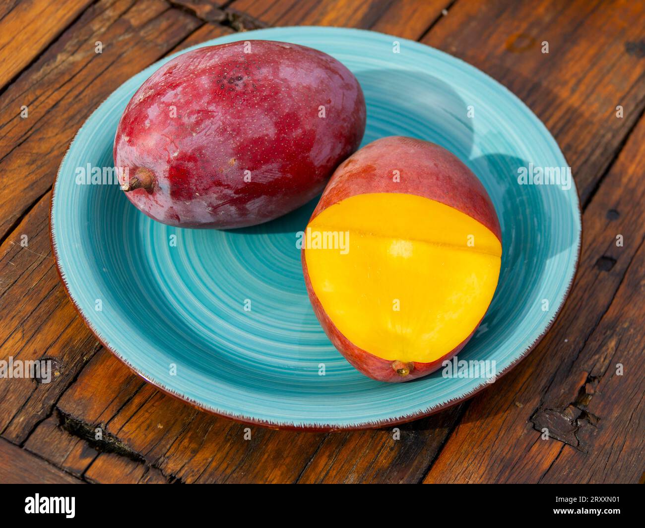 Mangos (Mangifera indica) on plate, yellow flesh, red skin, Osteen