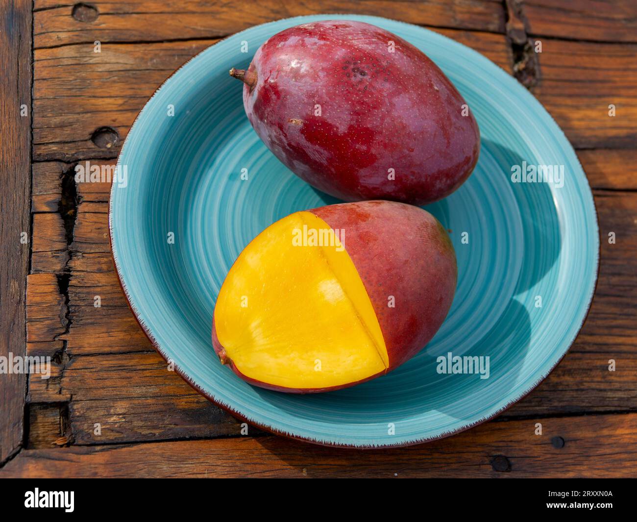 Mangos (Mangifera indica) on plate, yellow flesh, red skin, Osteen