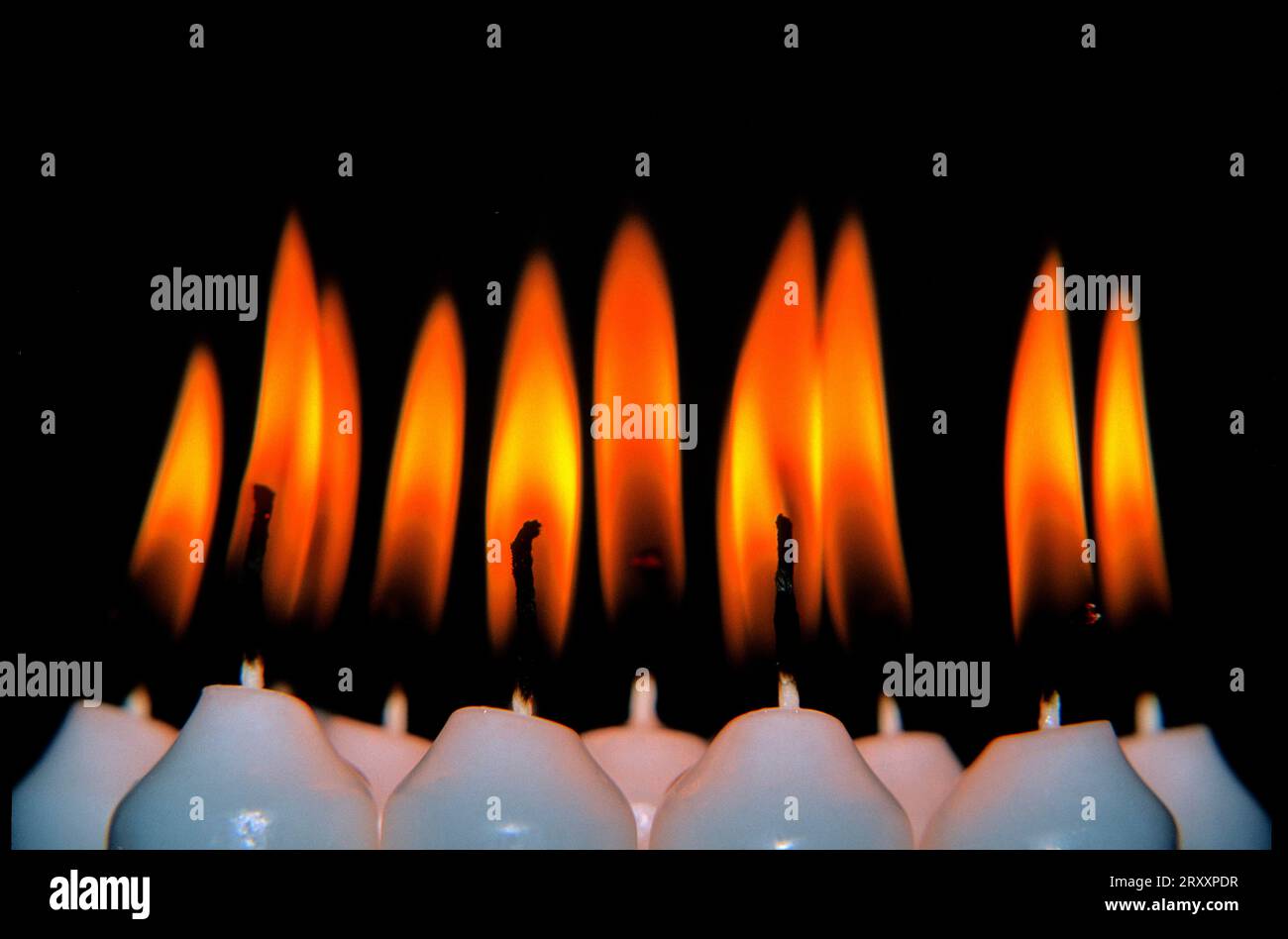 Burning candles, lit candles, different metallic colours Stock Photo