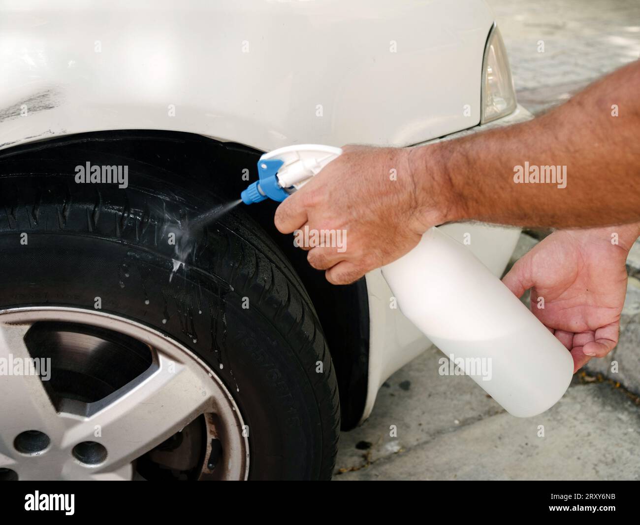 Applying foaming water spray to check if the car wheel is losing air