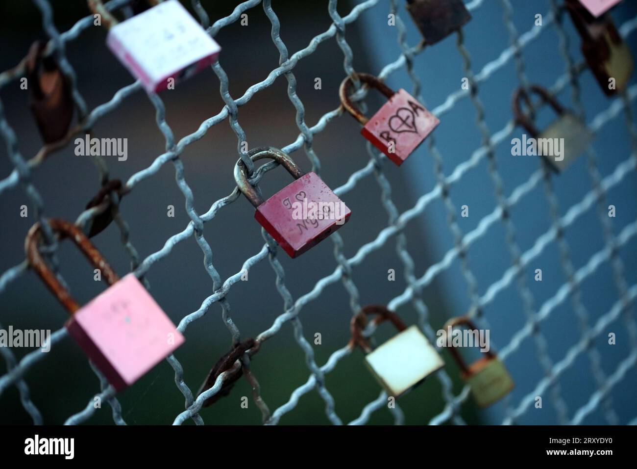 Old and new locks with names and dates written on them couples