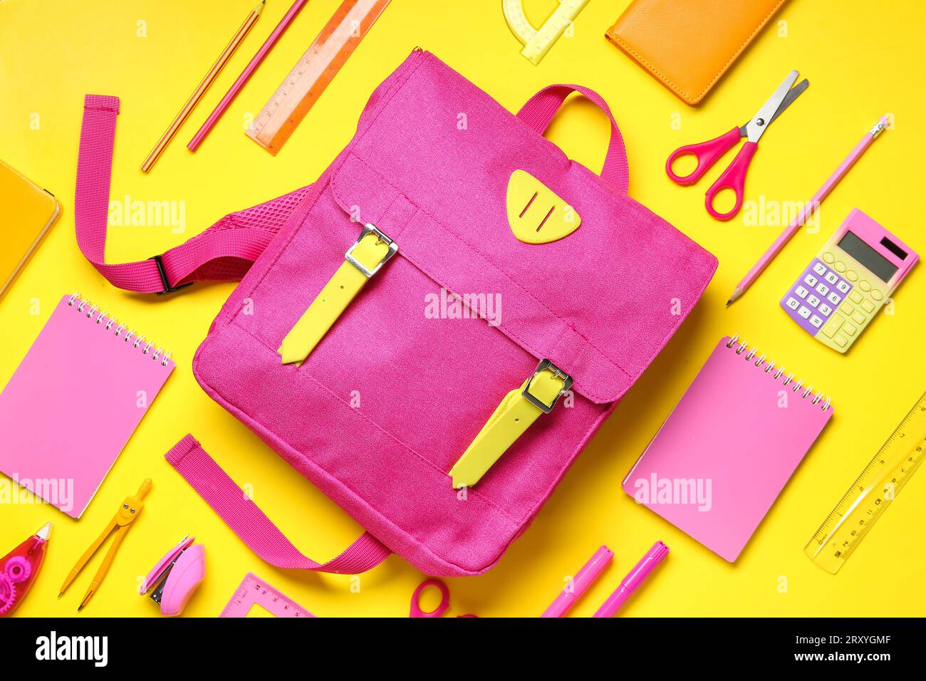 Stylish school backpack with different stationery on yellow background Stock Photo