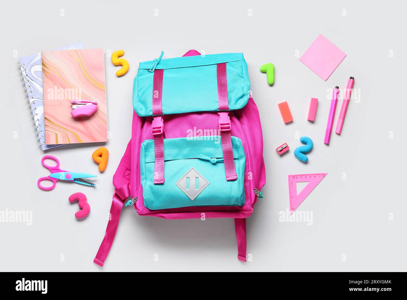 Stylish school backpack with different stationery on grey background Stock Photo